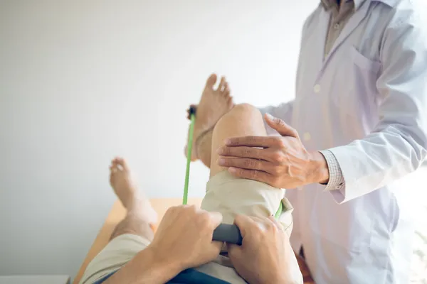 Fotografía de una hombre recostado en camilla siendo atendido por un profesional de la clínica de rodillas del Centro de la rodilla